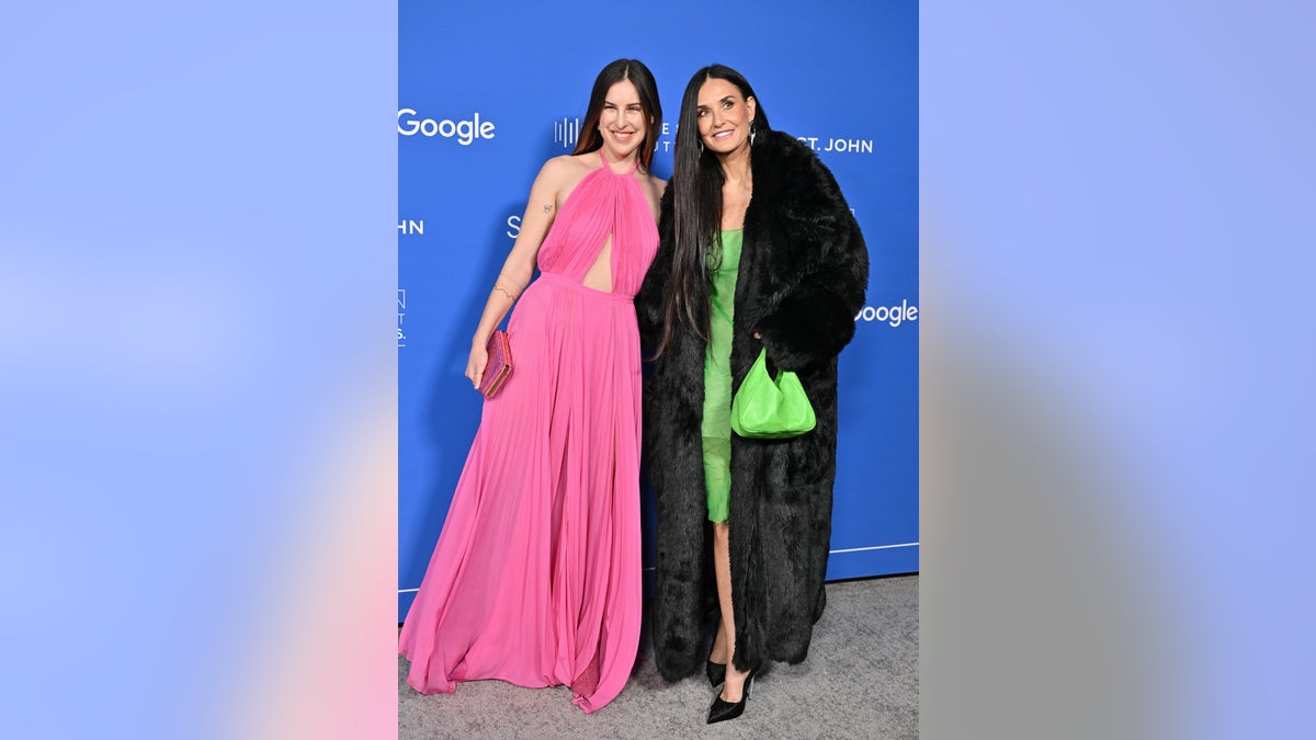 Scout Willis in pink dress and Demi Moore in green dress and black coat