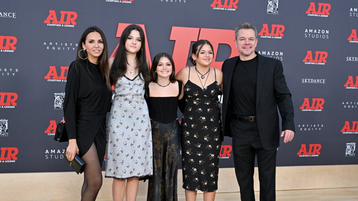 Luciana Barroso, Matt Damon, and three of their daughters pose in coordinating black ensembles on the carpet