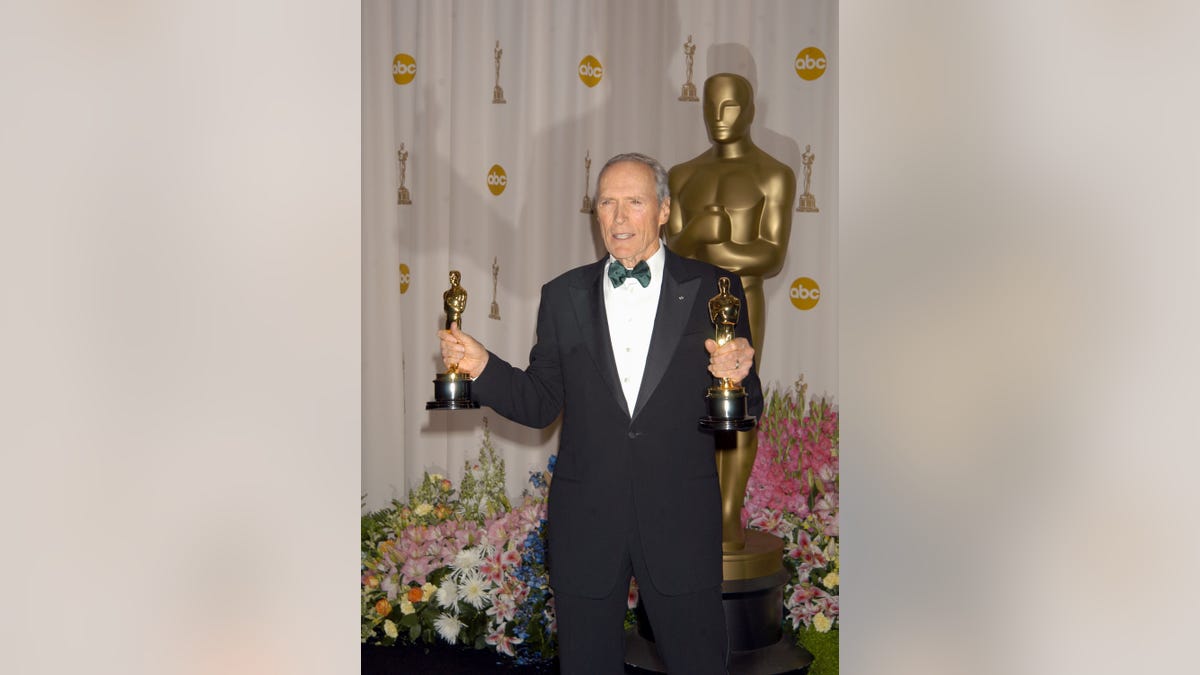 Clint Eastwood in a tuxedo holding his Oscars for "Million Dollar Baby"