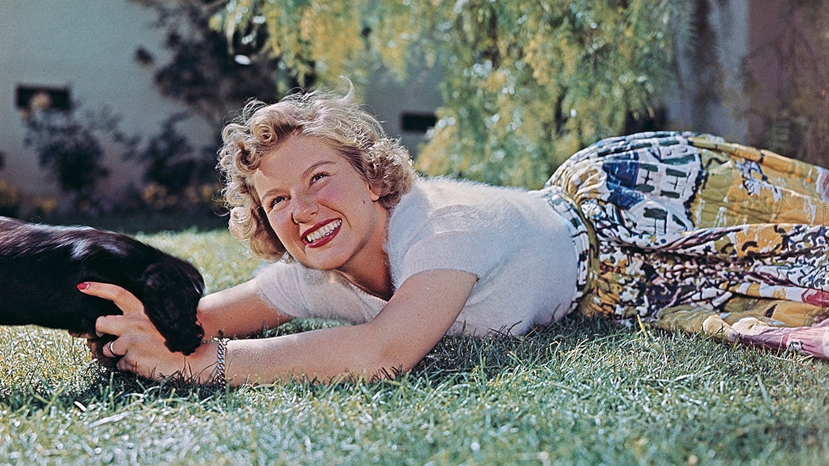 Barbara Bel Geddes petting a dog in 1950