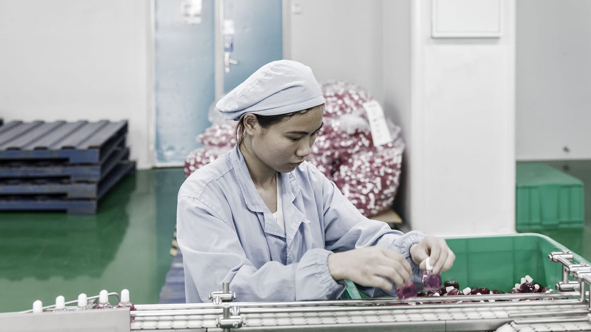 Chinese factory worker on a medical equipment manufacturing line. 