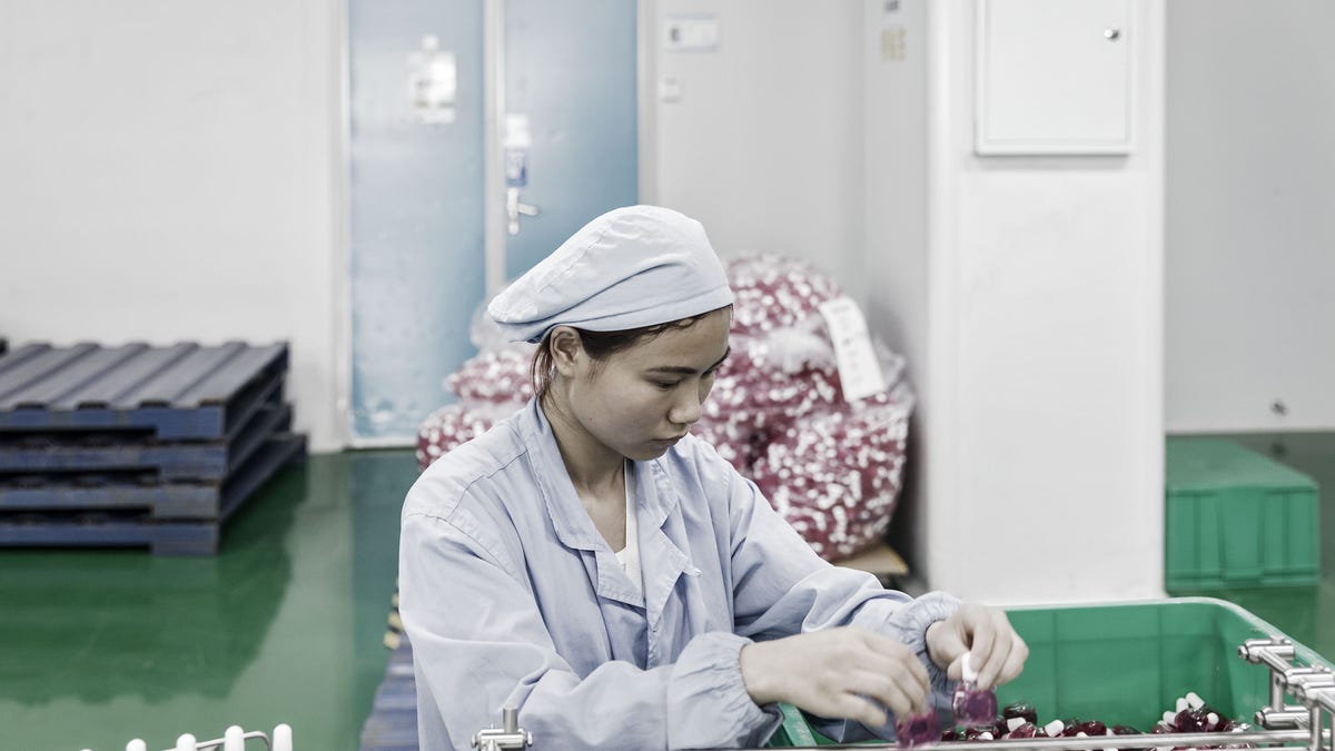 Chinese factory worker on a medical equipment manufacturing line.