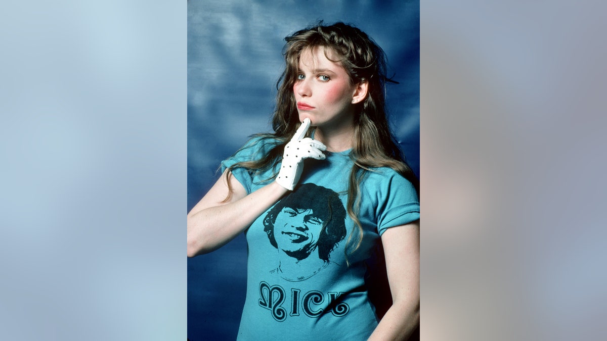 A photo of Bebe Buell wearing a blue t-shirt with Mick Jagger's face on it