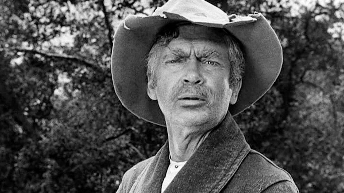 A close-up black and white photo of Buddy Ebsen as Jed Clampett