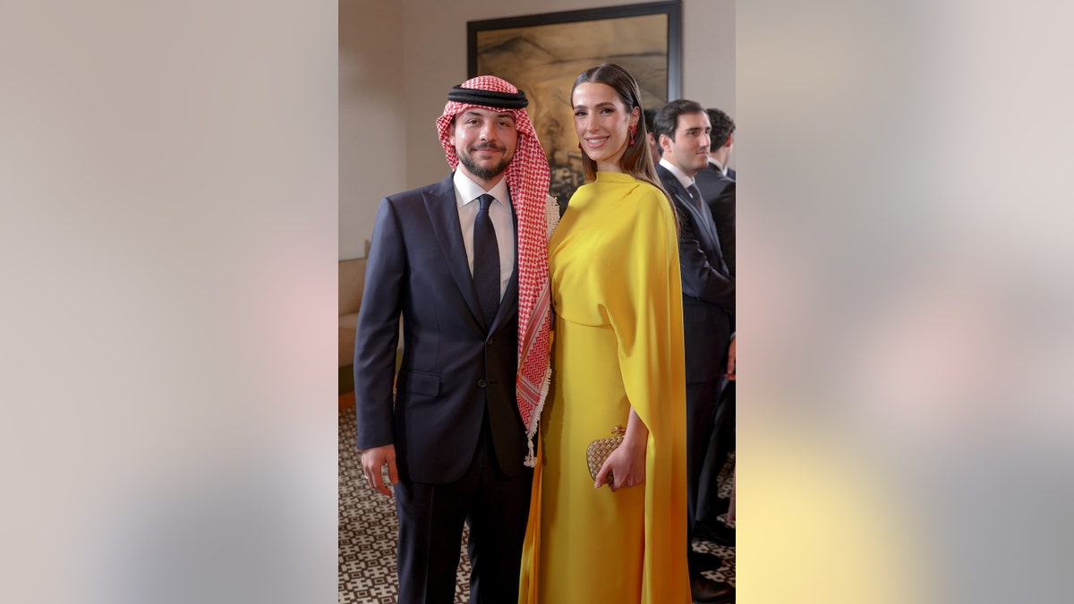 Crown Prince Hussein and his fiancee smiling for a posed photo