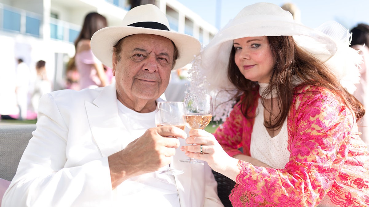 Paul Sorvino and Dee Dee Sorvino wearing white while enjoying a glass of rose