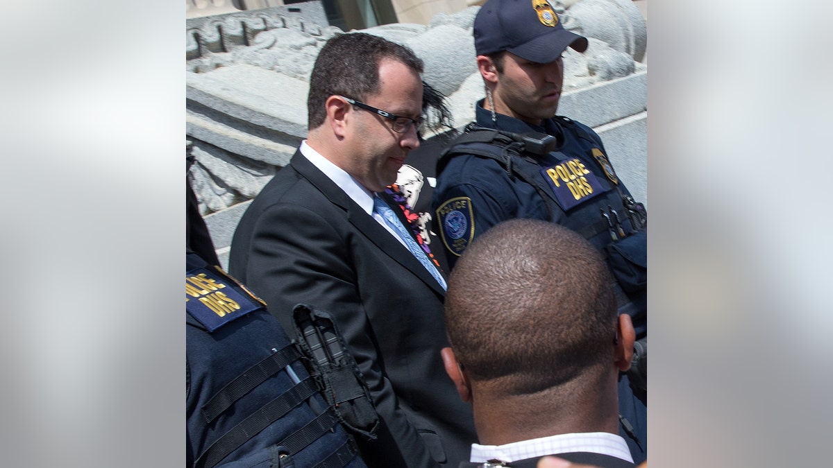 Jared Fogle leaving a courthouse surrounded by police