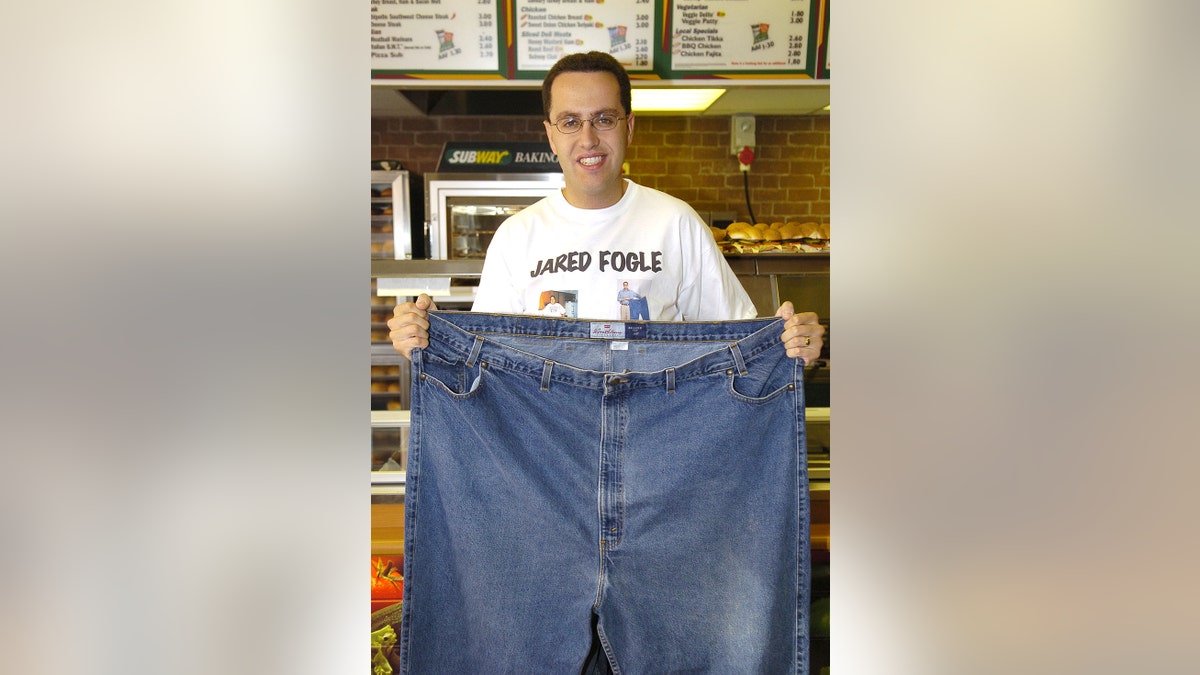 Jared Fogle holding a pair of wide jeans