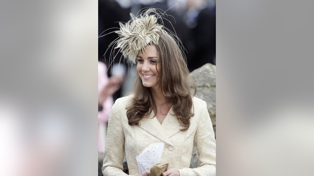 Kate Middleton wearing an ivory dress and fascinator while she was dating Prince William