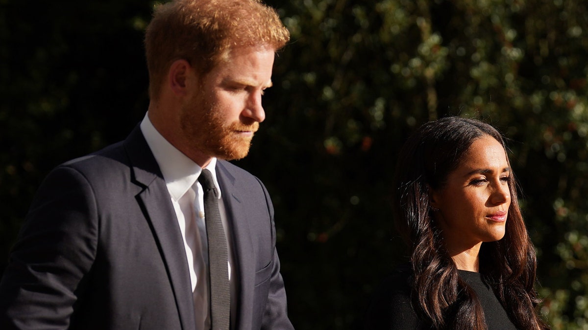 Meghan Markle and Prince Harry looking serious and away from the camera