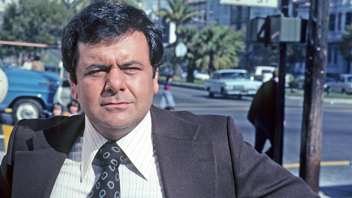 A young Paul Sorvino in a grey suit