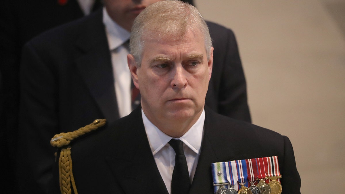 Prince Andrew looking stern in a suit with multiple medals