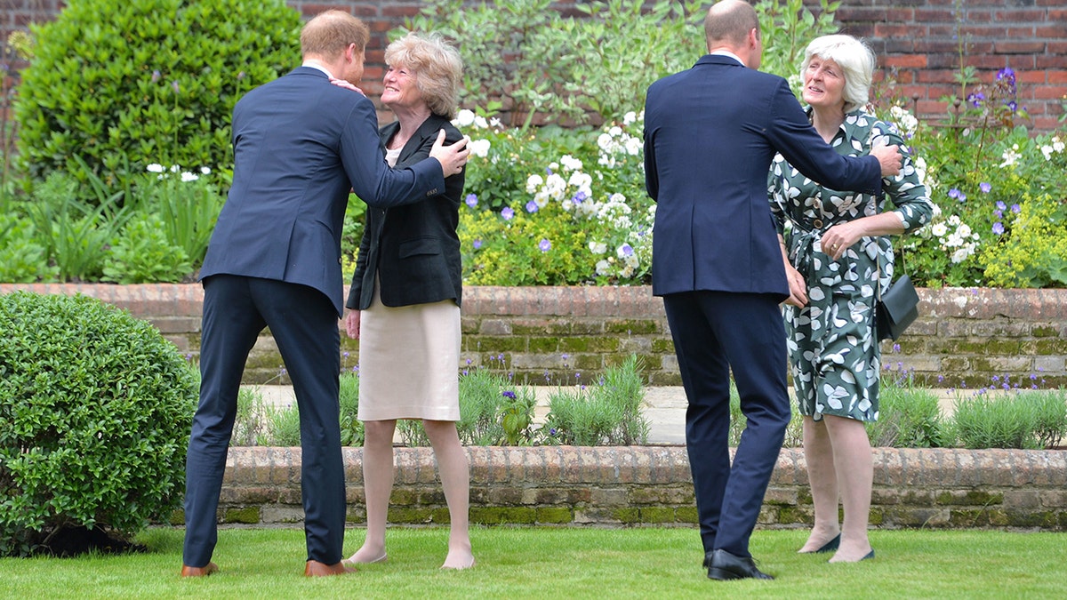 Prince Harry and Prince William in navy suits embracing their aunts, Princess Diana's sisters