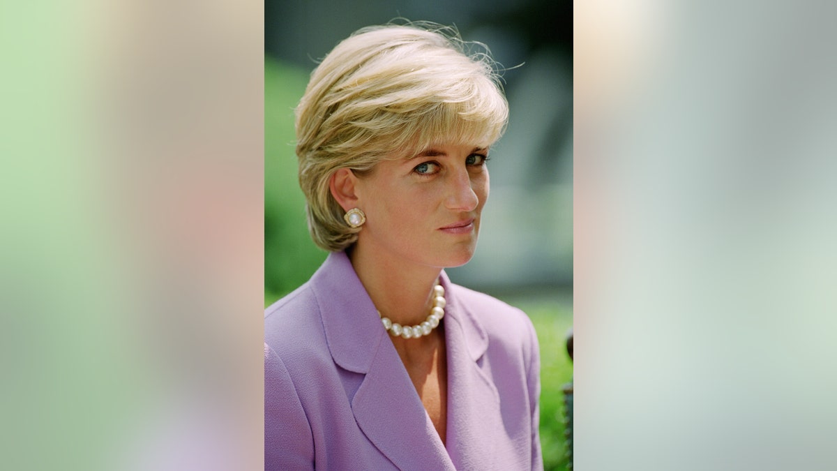 A close up of Princess Diana wearing a liliac suit