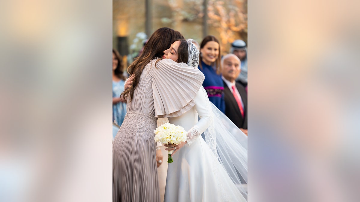 Princess Iman of Jordan being embraced by her mother the queen