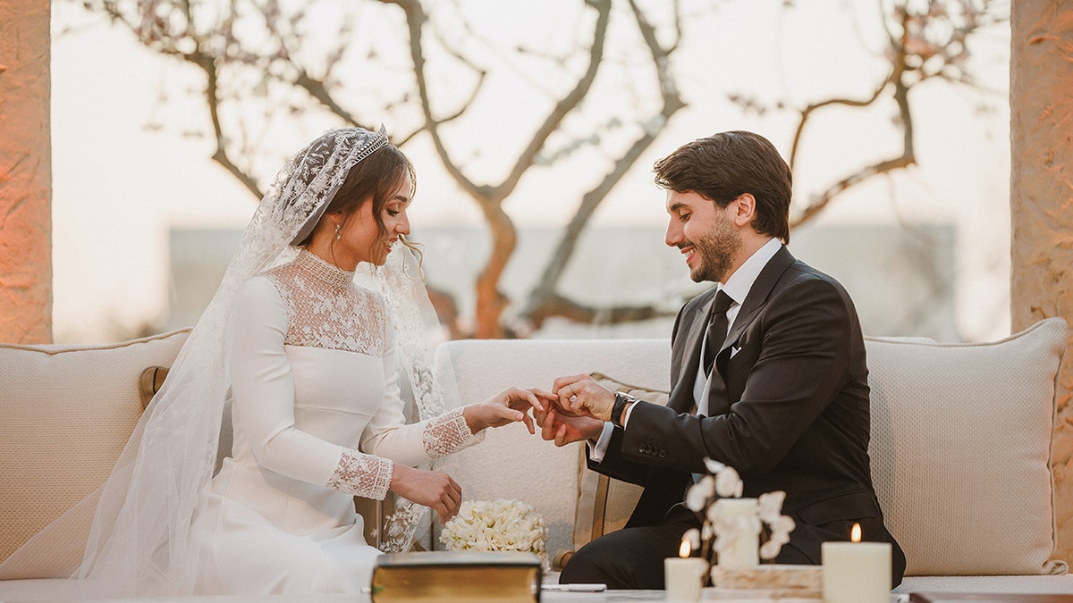 Jameel Alexander Thermiotis placing a ring on the finger of Princess Iman of Jordan