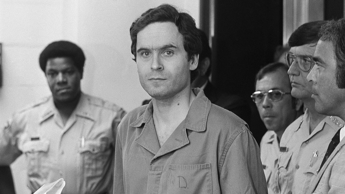Ted Bundy in a jumpsuit looking directly at the camera