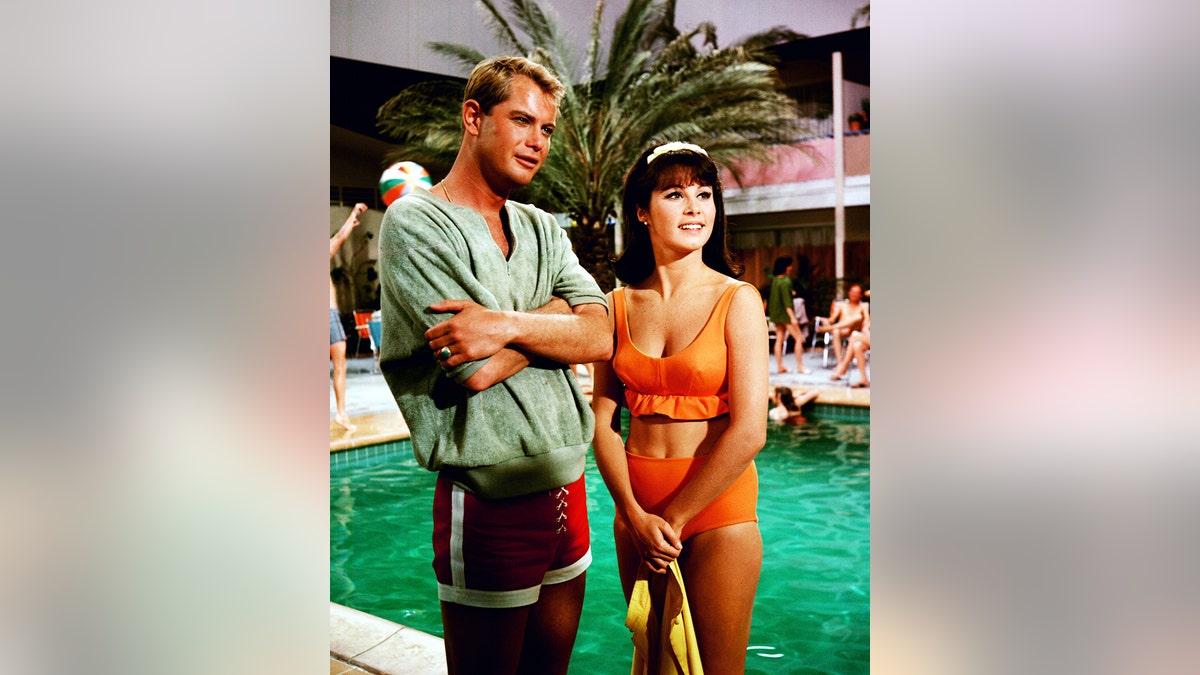 Troy Donahue standing by a pool in a scene from the film Palm Springs Weekend