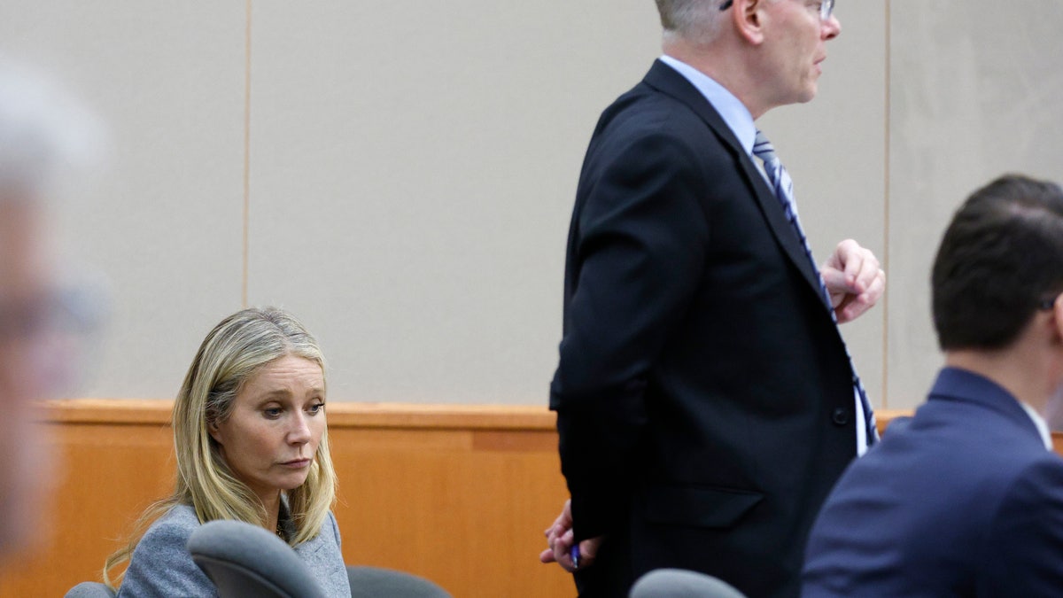 Steve Owens wears black blazer next to Gwyneth Paltrow in court