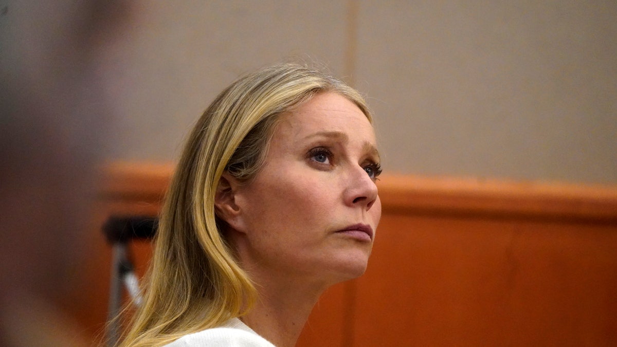 Gwyneth Paltrow sits in court wearing white coat