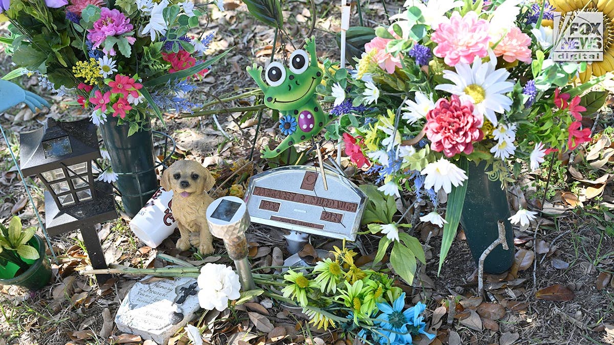 Temporary grave marker surrounded by fake flowers