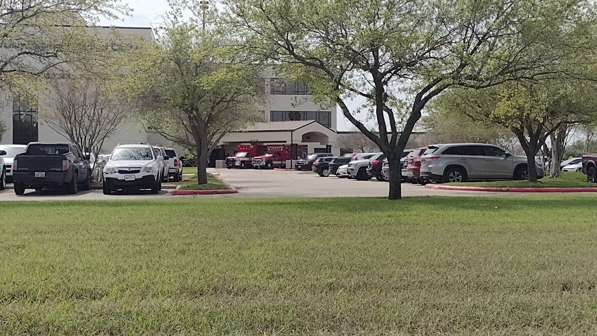 A wide shot of a hospital with two read ambulances