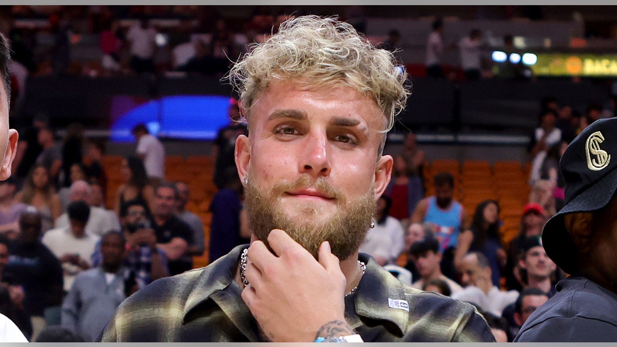 Jake Paul smiles courtside