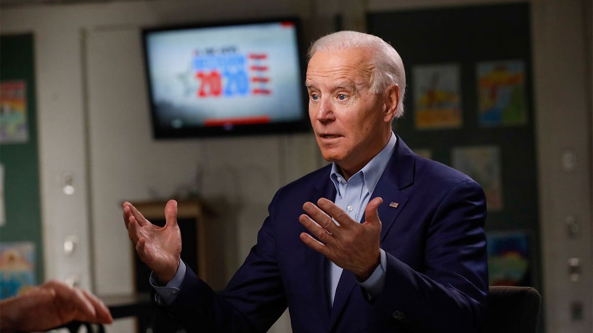 President Biden sitting down with his arms up as he explains a story in his interview.