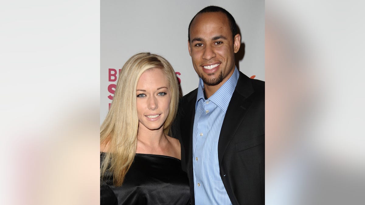 Hank Baskett and Kendra Wilkinson pose on red carpet.