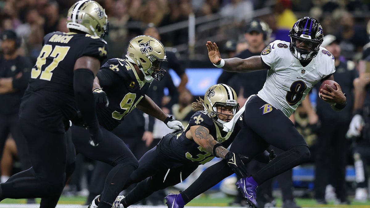 Lamar Jackson runs with the football