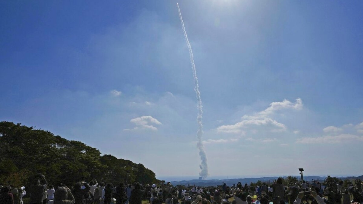 People watch as an H3 rocket is launched