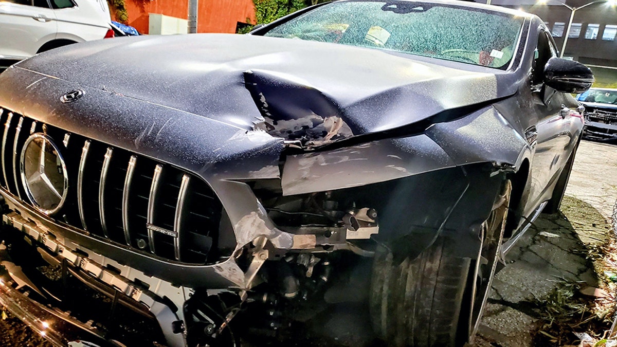 Image of the dark colored Mercedes sedan involved in the Pete Davidson accident, with a dented front bumper, hood, and broken windshield