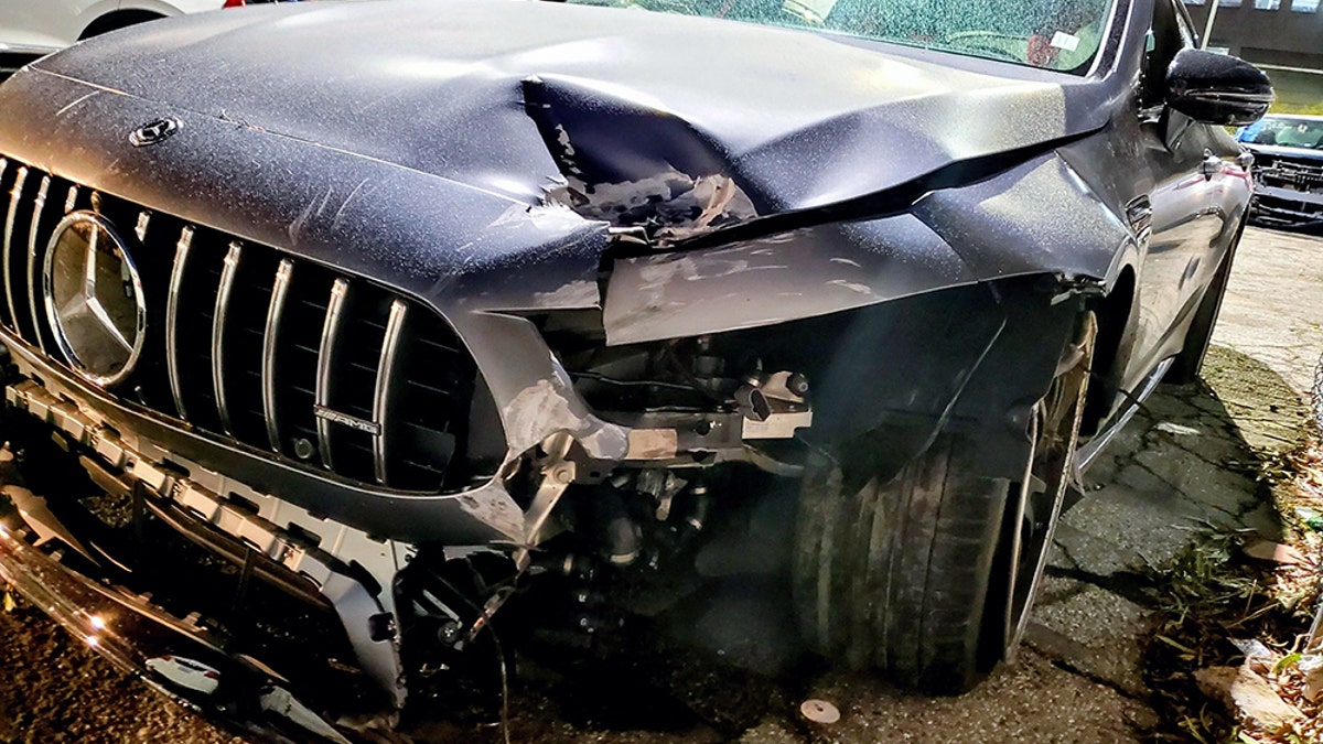 Image of the dark colored Mercedes sedan involved in the Pete Davidson accident, with a dented front bumper, hood, and broken windshield