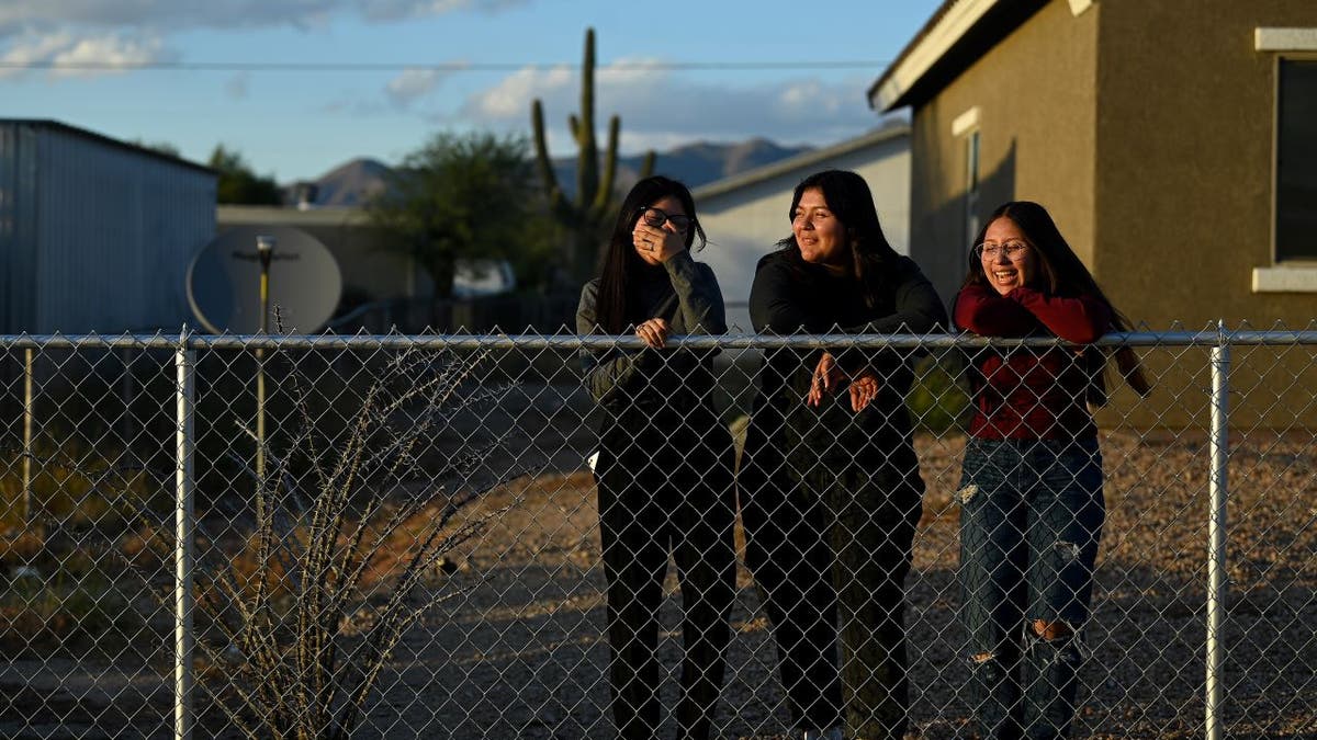 Native American girls at fence