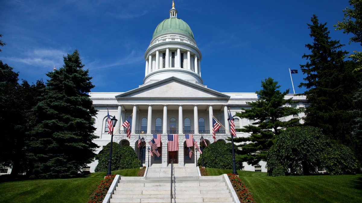 Maine state capitol building with US flags