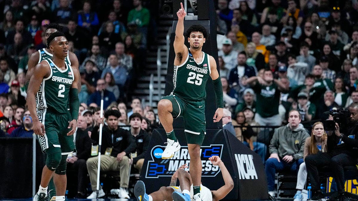 Malik Hall points down the court