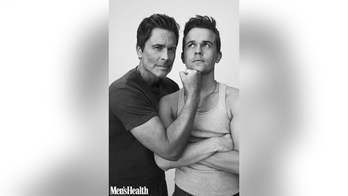 Black and white of Rob Lowe playfully interacting with son John Owen Lowe