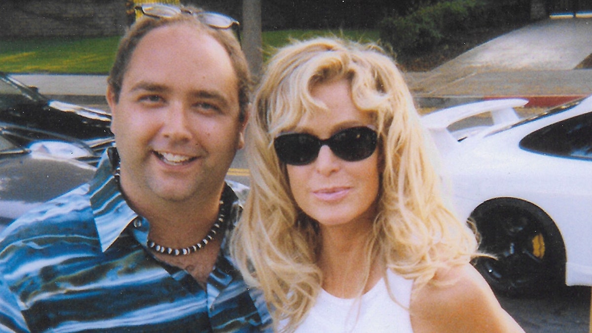 Mike Pingel wearing a striped shirt next to Farrah Fawcett who is wearing a sleeveless white tank top and black sunglasses