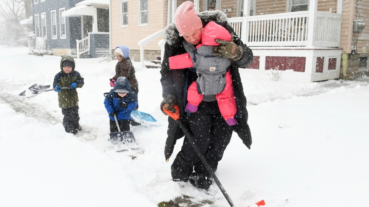 A New York mother and her kids shovel snow