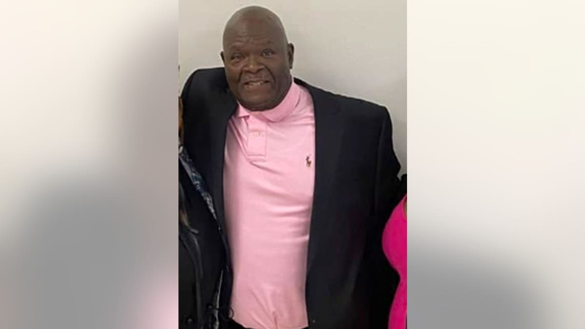 Mike Hill in a pink polo and black blazer posing for a photo.