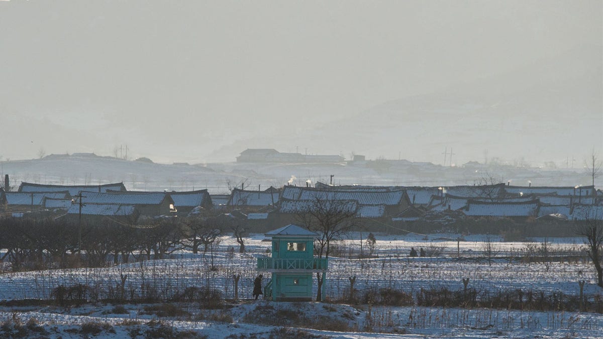 FILE: The portraits of late North Korean leaders Kim Il-Sung (L) and Kim Jong-Il (R) are seen in North Korea's Sakchu county in North Pyongan province, as seen from the Chinese border city of Dandong.