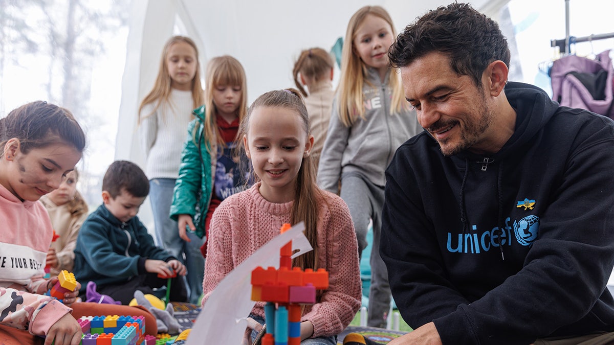 Orlando Bloom playing with children during his UNICEF trip to Ukraine