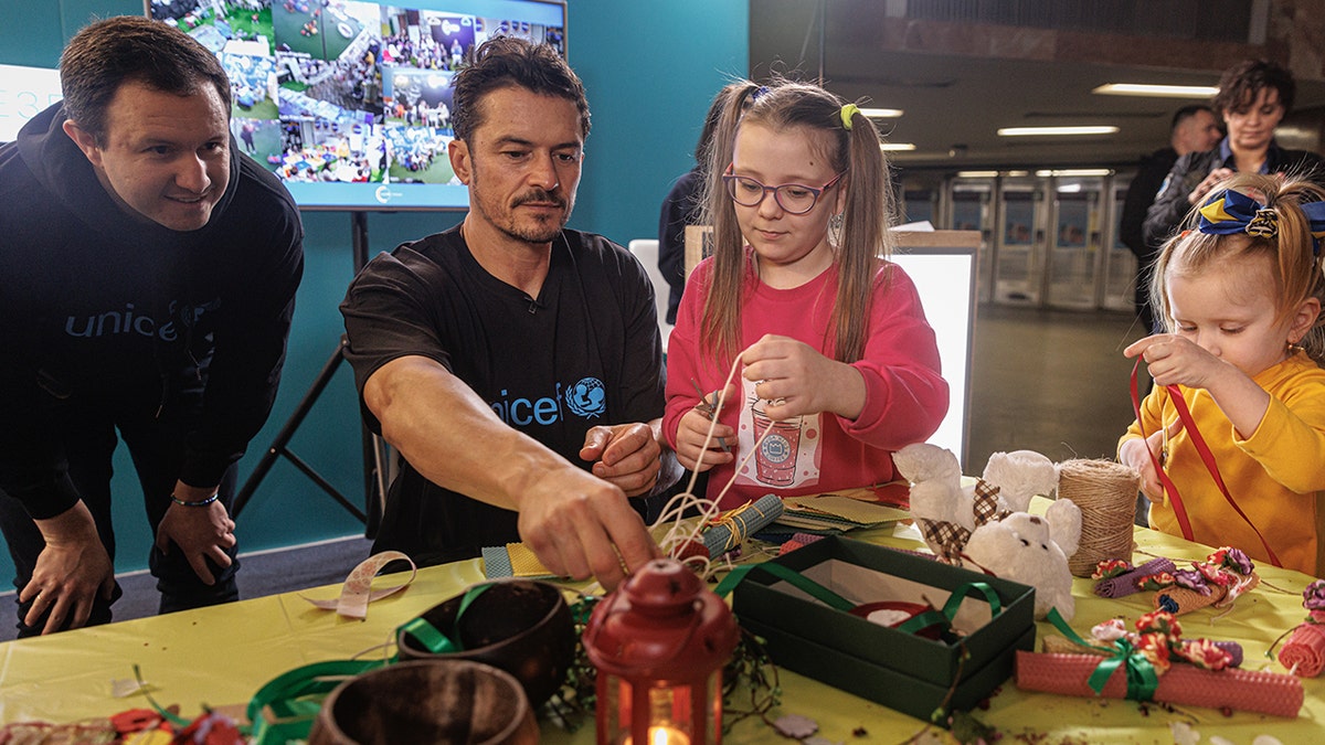 Orlando Bloom doing crafts with children displanced in Ukraine