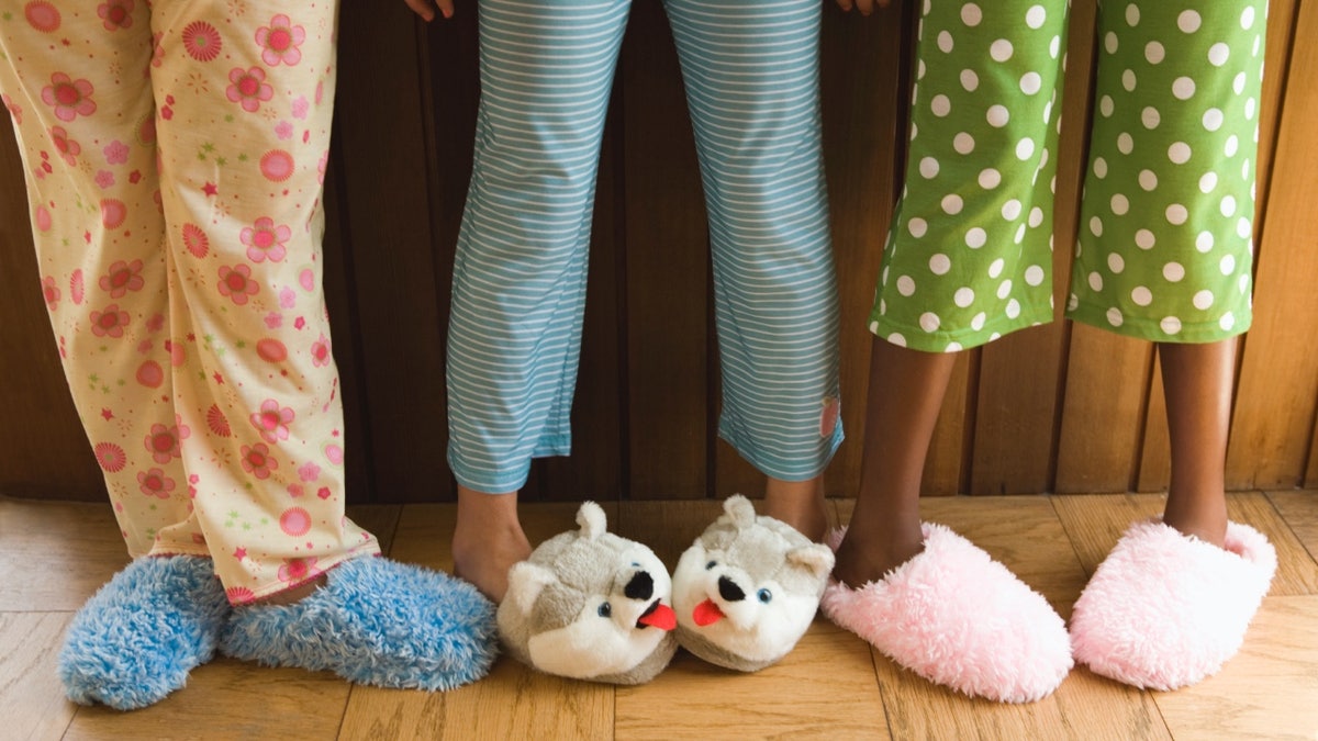 Stock image of young girls in pajama pants and fuzzy slippers