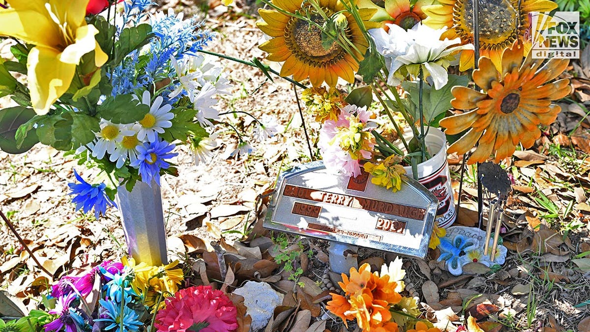 Temporary grave marker surrounded by fake flowers