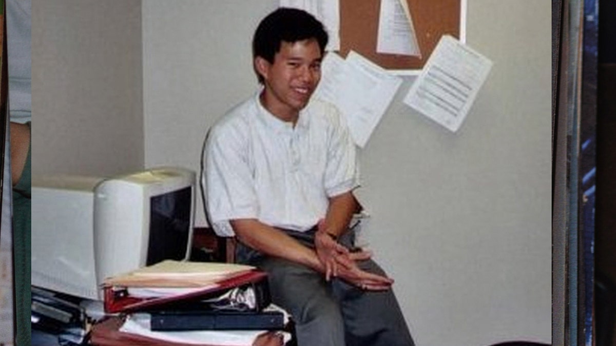 A photo of Robert Wone sitting on top of a desk