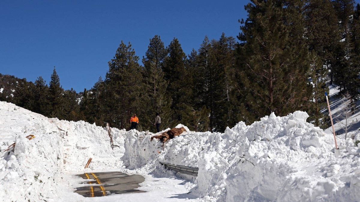 Caltrans workers inspect the damage caused by an avalanche