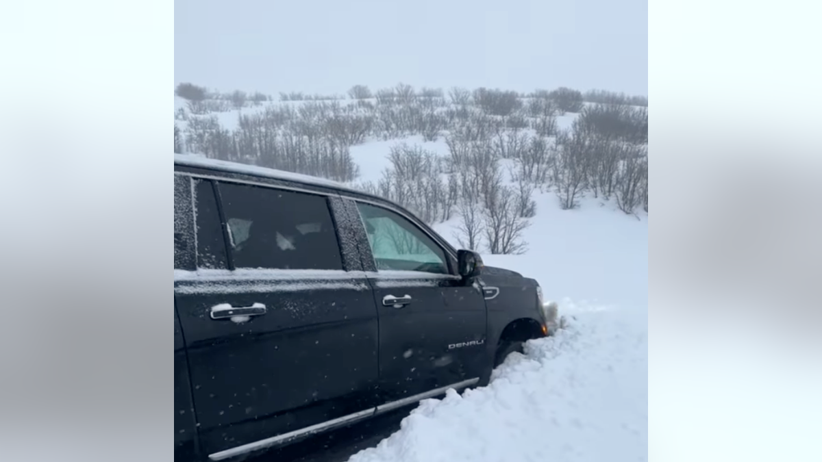 Car stuck in snowpile amid snowstorm