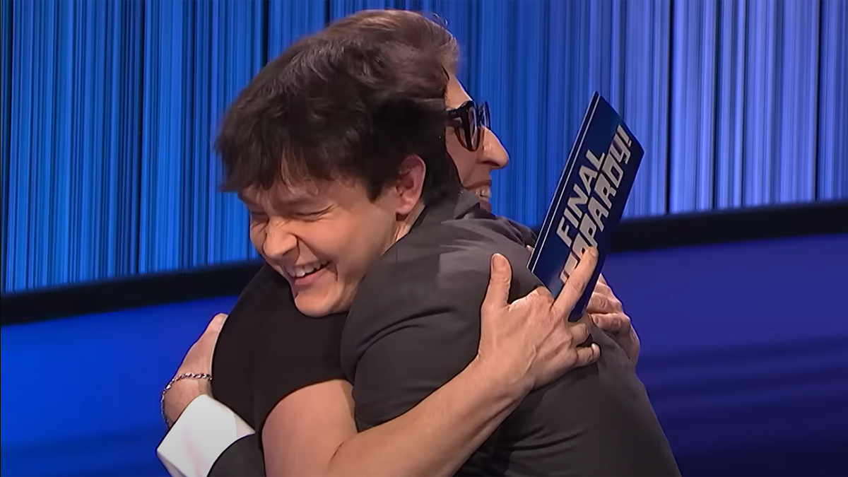 Mayim Bialik hugs "Jeopardy!" winner Justin on stage