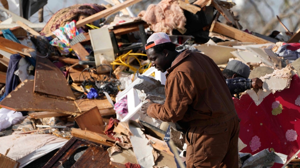 A resident looks through the piles of debris in Rolling Fork, Miss.